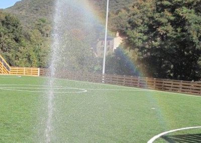 Arrosage du terrain de sport avec l'apparition d'un arc-en-ciel